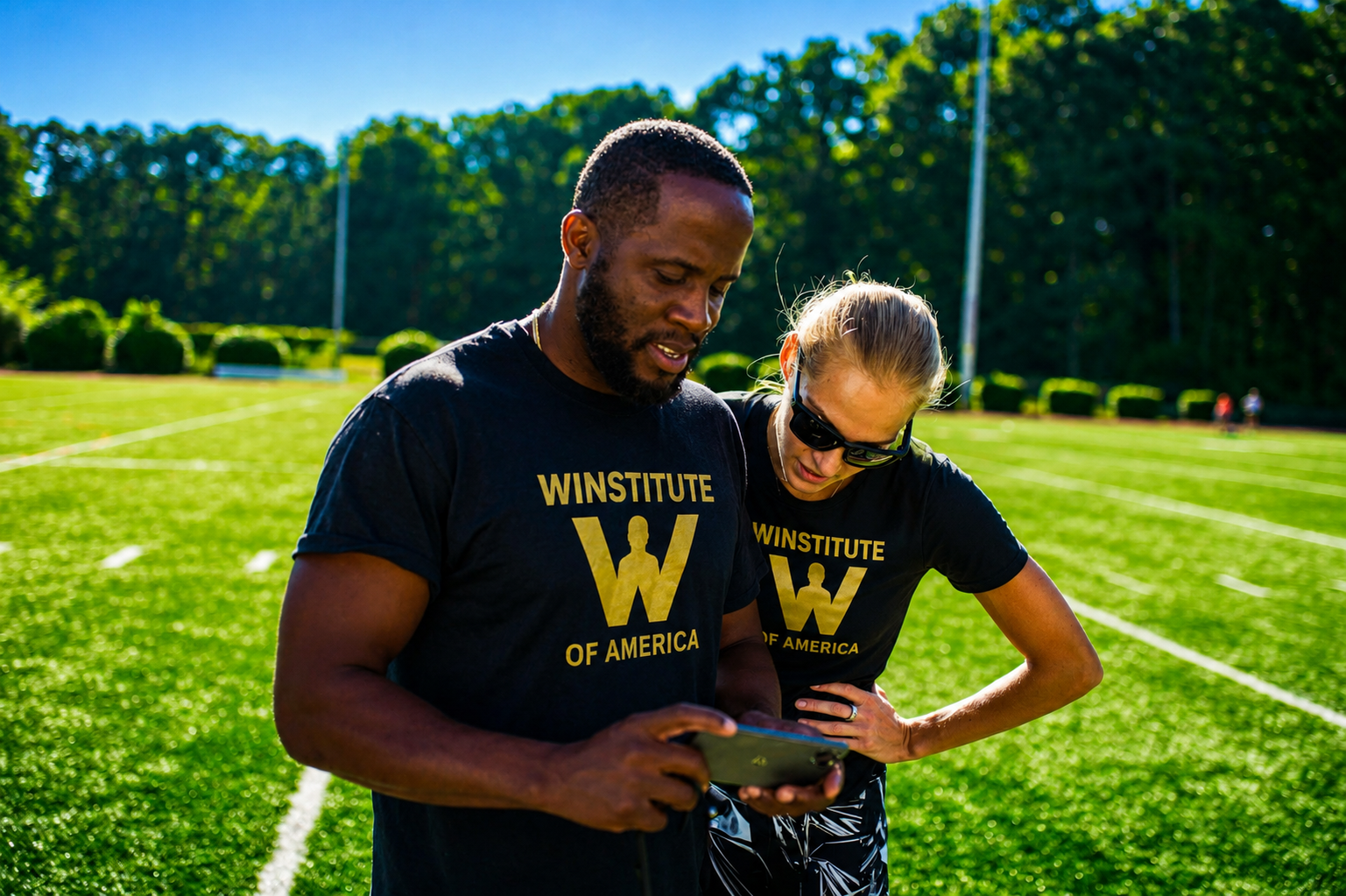Winstitute coaches reviewing athlete data on a tablet